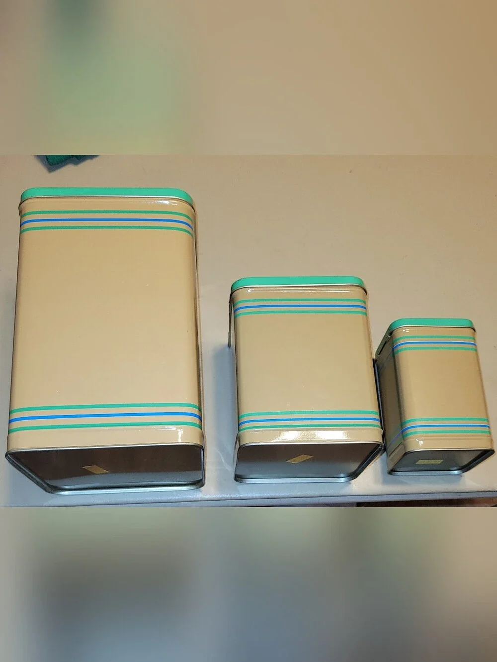 LASLO - Set of 3 Nesting Tan Metal Canisters with Green Lids and Stripes.